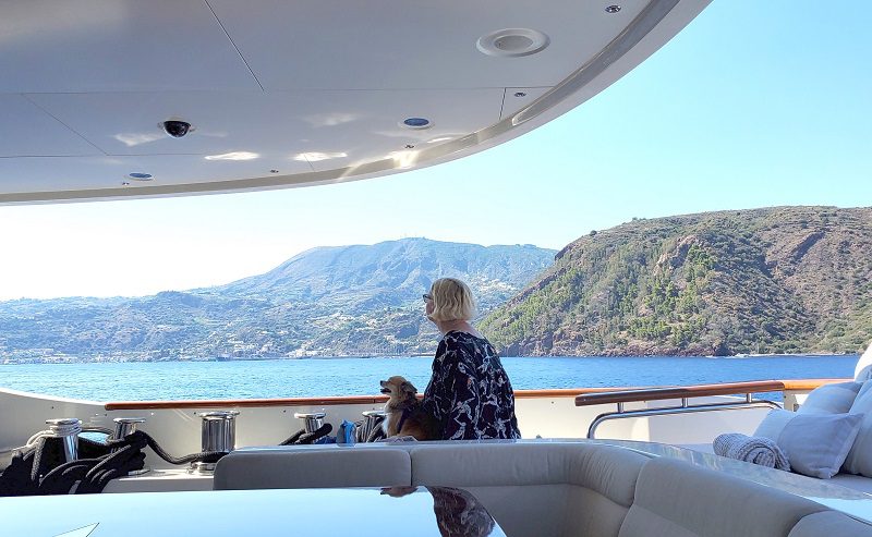 A person enjoying a serene moment on a yacht's sun deck overlooking the ocean