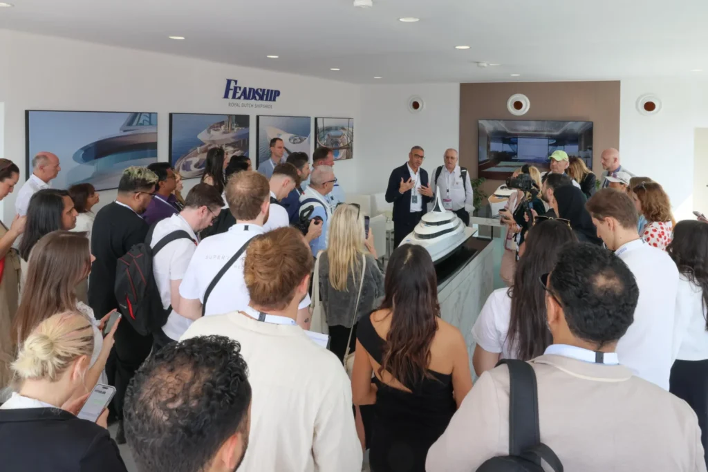 A crowd gathers for a presentation at the Feadship stand.