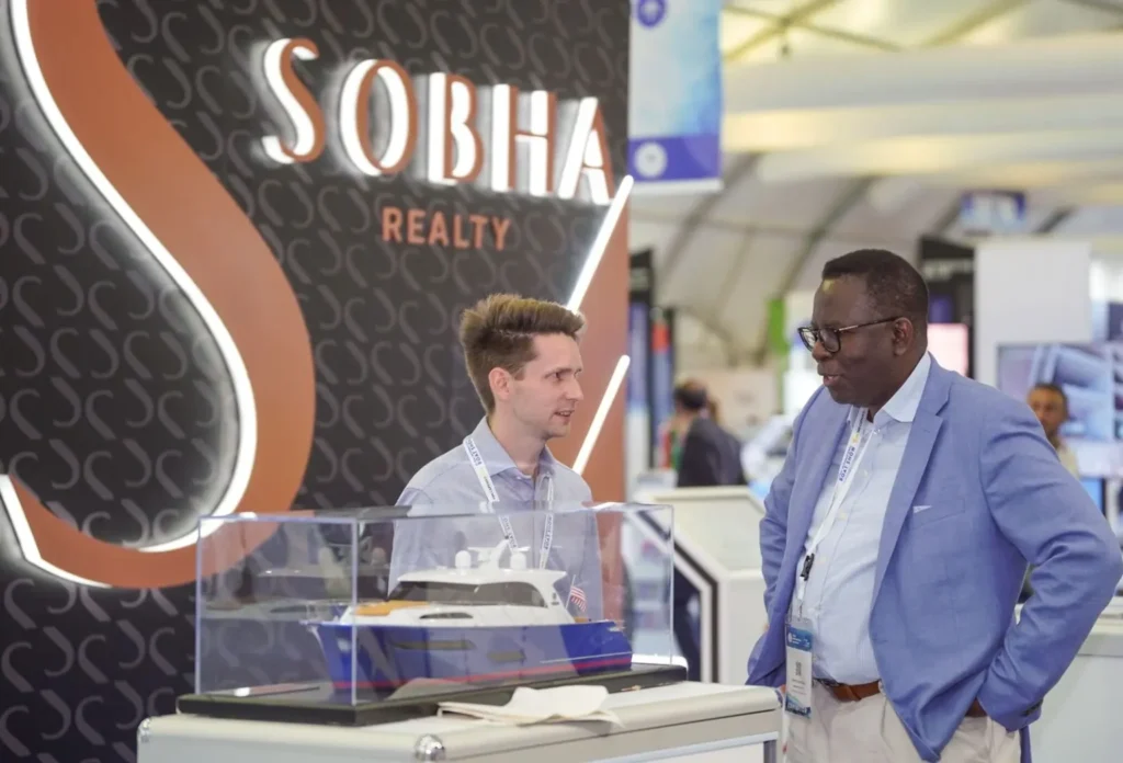 A visitor speaks with a representative at the Sobha Realty stand.